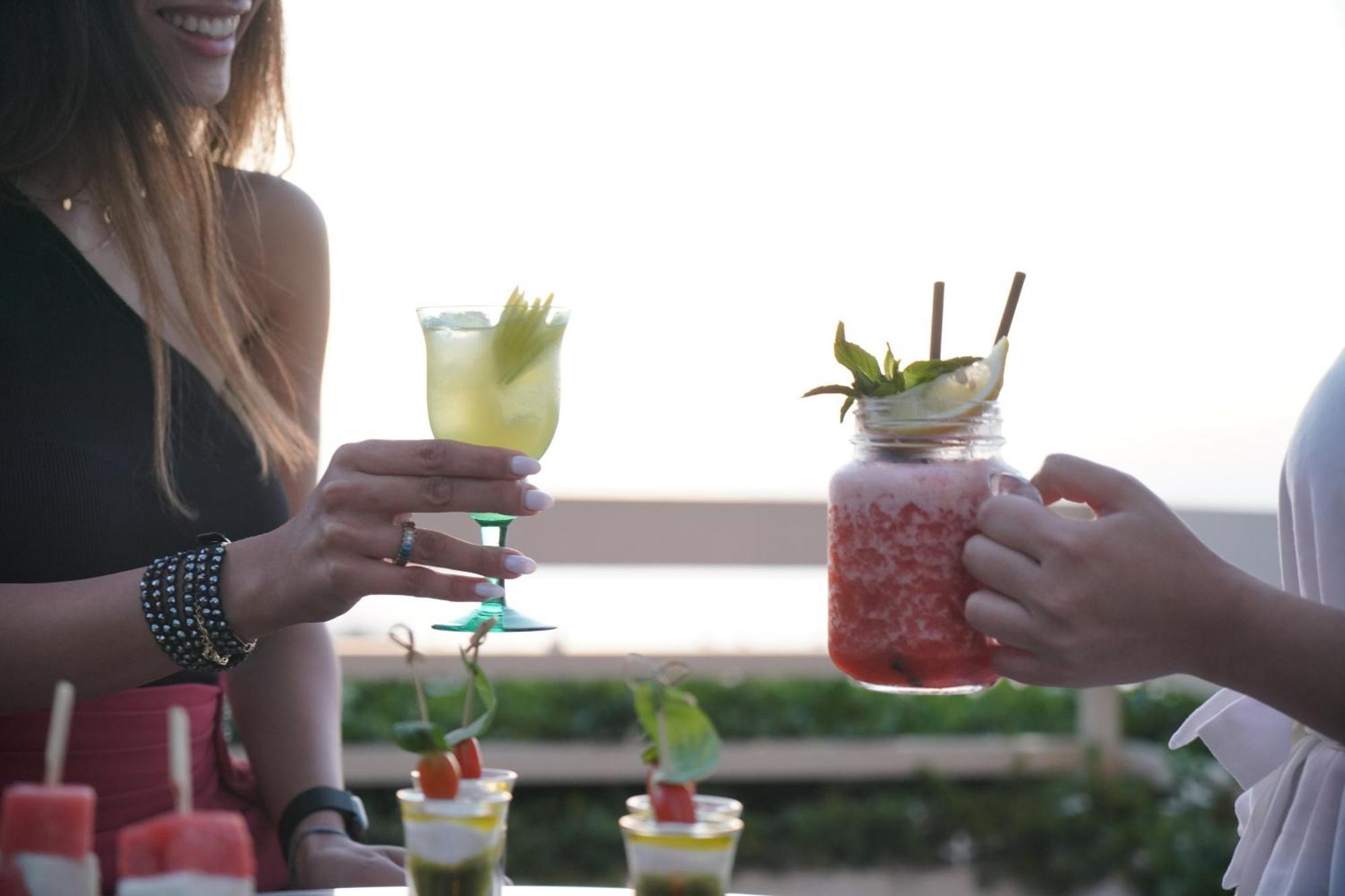 Отель Gefinor Rotana - Бейрут Экстерьер фото Two people holding cocktails
